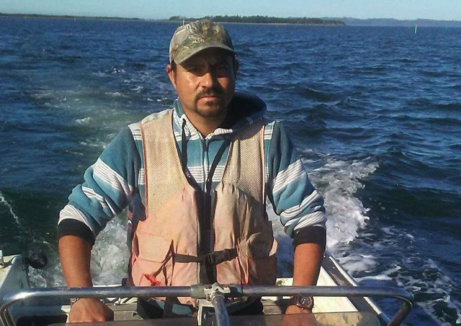 Aburto Gutierrez drives a boat with harvested clams near Wallapa Bay.