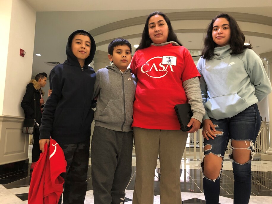 Maribel Cortez poses in a "CASA" shirt next to 3 of her children at the Maryland General Assembly.