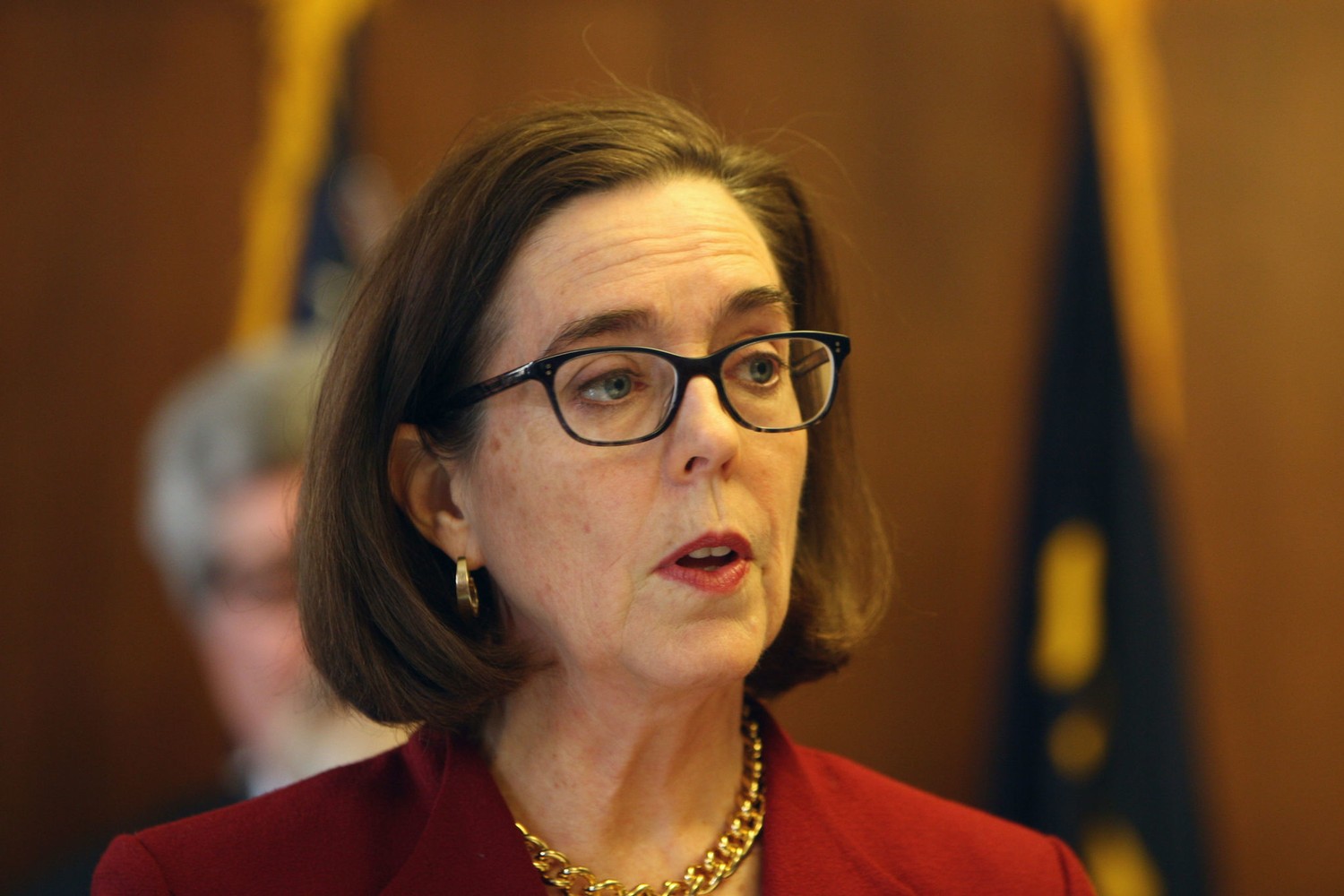 Gov. Kate Brown stands at a podium as she announces an executive order protecting Oregon immigrants.